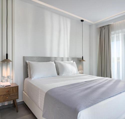 a white bedroom with a large bed and a window at Myzith Luxury Suites in Keri