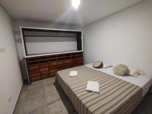 a bedroom with a bed with two white towels on it at Jencquel Home in Coronel Suárez