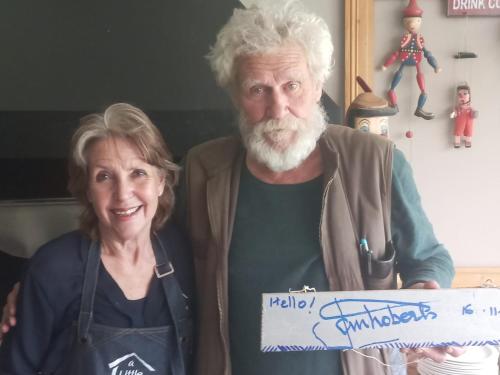 a woman and an older man holding a sign at A Little Guesthouse in Bloemfontein