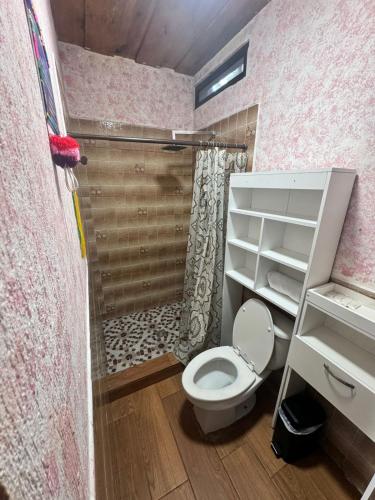 a small bathroom with a toilet and a shower at Hanna Suites in Panajachel