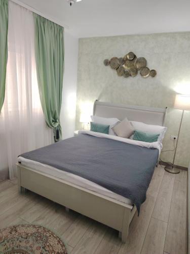 a bedroom with a large bed with green curtains at RELAX Downtown Suite in Constanţa