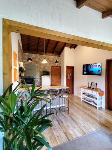 a kitchen and living room with a table and chairs at Casa das Dunas in Garopaba