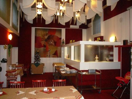 a restaurant with tables and chairs and a chandelier at Pension Schaumannův Dvůr in Karlovice