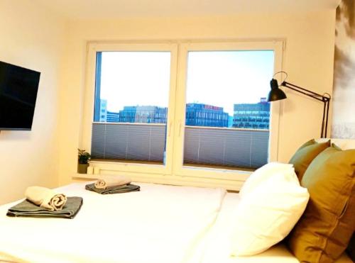 コシツェにあるLuxusný apartmán New Yorkのベッドルーム1室(窓、ベッド1台、タオル2枚付)