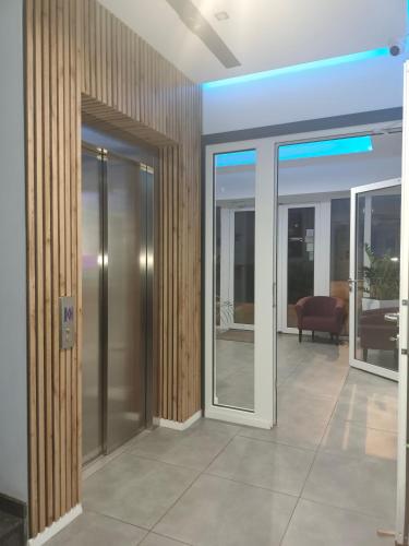 a lobby with sliding glass doors and a couch at Hotelik & Restauracja Amber in Raszyn