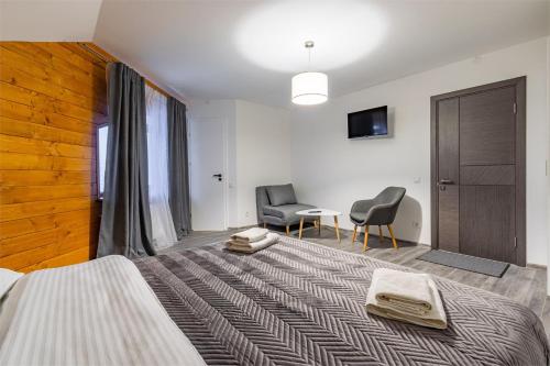 a bedroom with a bed and two chairs and a table at Forest Home in Bukovel