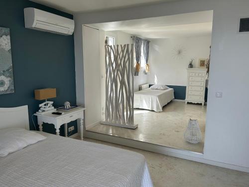 - une chambre avec un lit et un miroir dans l'établissement Villa Les Mimosas, à Roquebrune-sur Argens