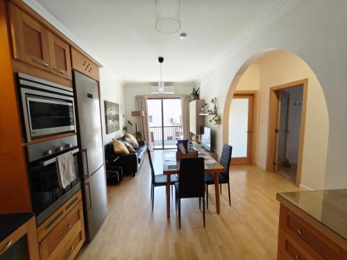 a kitchen and living room with a table and chairs at Gaia St Paul's Bay Modern Cosy Apartment Qawra Bugibba in St. Paul's Bay