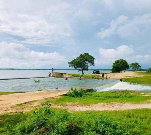 a group of people in the water on a beach at Yala Lucas Lake Hotel in Tissamaharama