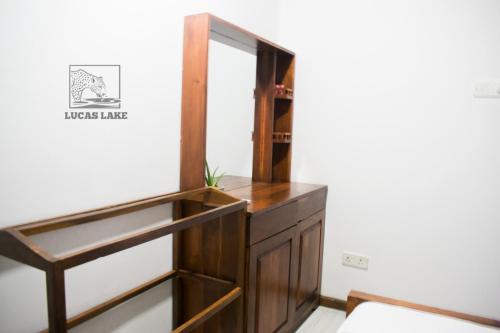 a dressing room with a mirror and a wooden cabinet at Yala Lucas Lake Hotel in Tissamaharama