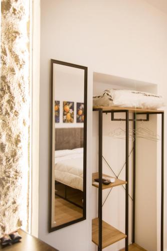 a mirror on a wall next to a bed at La Zagara in Favara