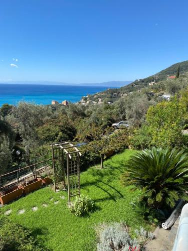 uitzicht op een tuin met de oceaan op de achtergrond bij casa lella home in Recco