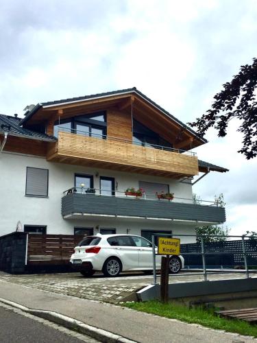 a white car parked in front of a house at Alpinelounge -modern - spacious in Waltenhofen