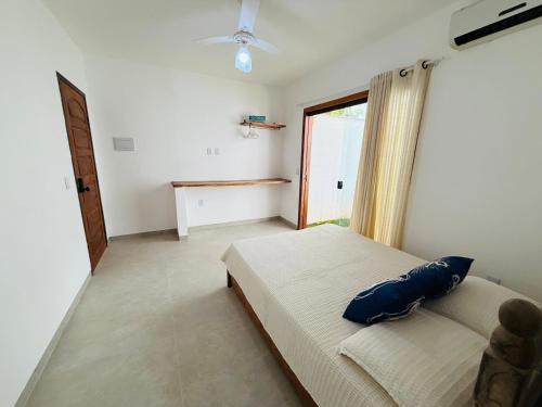 a bedroom with a bed with a blue pillow on it at Pousada Do Sol in Porto Seguro