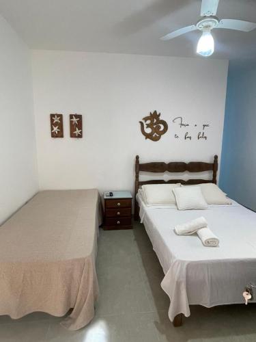 a bedroom with two beds and a ceiling fan at Pousada Do Sol in Porto Seguro