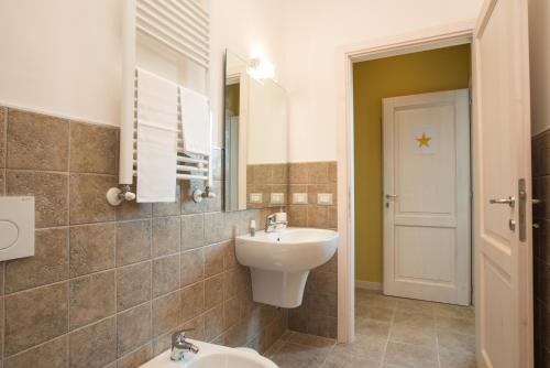 a bathroom with a sink and a toilet and a mirror at Fattoria Didattica La Collina Incantata in Narni