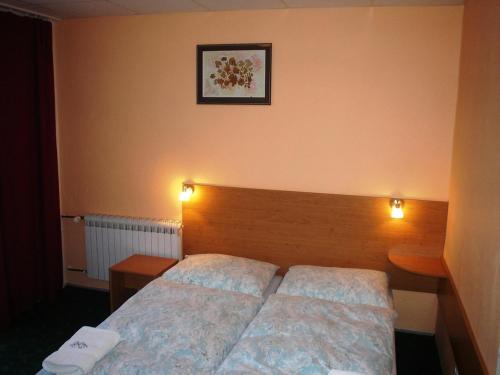 a bedroom with a bed and two lights on the wall at Pension Schaumannův Dvůr in Karlovice