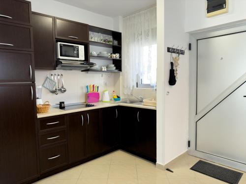 a kitchen with a sink and a microwave at Cosy two-bedroom apartment in Becici by sea and mountains in Becici