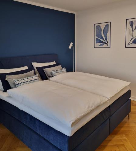two beds in a bedroom with a blue headboard at Im Zentrum von Leverkusen, helle 3-Zimmerwohnung 80 m2 in Leverkusen