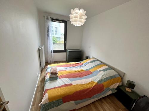 - une chambre avec un lit et une couverture colorée dans l'établissement Nice flat in la Plaine St Denis, à Saint-Denis