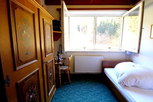 a small bedroom with a bed and a window at Hotel Sonnleitn in Jenig