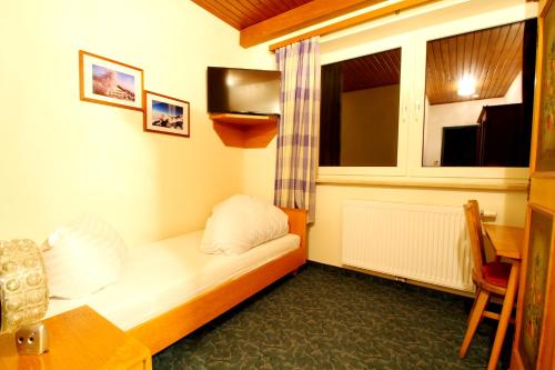 a small room with a bed and a window at Hotel Sonnleitn in Jenig