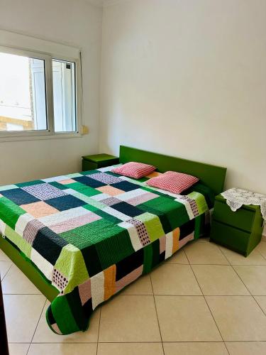 a bedroom with a bed with a colorful quilt on it at GRILL&SEA apartments in Perea