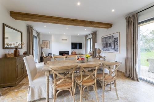 une cuisine et une salle à manger avec une table et des chaises en bois dans l'établissement Maison du Haras Norman house near Deauville, à Cricquebœuf