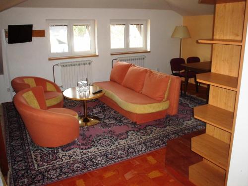 a living room with a couch and a table and chairs at Pension Schaumannův Dvůr in Karlovice