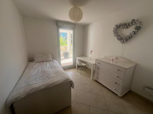 - une chambre avec un lit, un bureau et un mur au cœur dans l'établissement T3 TERRASSE SUD Marseille 13009, PARC DES CALANQUES, à Marseille