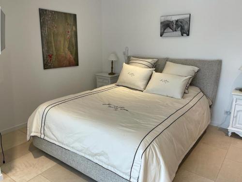 une chambre avec un lit avec des draps blancs et des oreillers dans l'établissement Charming sea view villa with pool, à Hyères