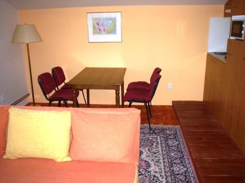 a living room with a couch and a table and chairs at Pension Schaumannův Dvůr in Karlovice