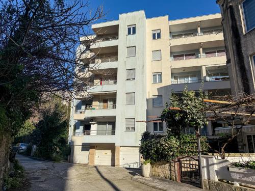 an apartment building in front of a street at Cosy two-bedroom apartment in Becici by sea and mountains in Becici