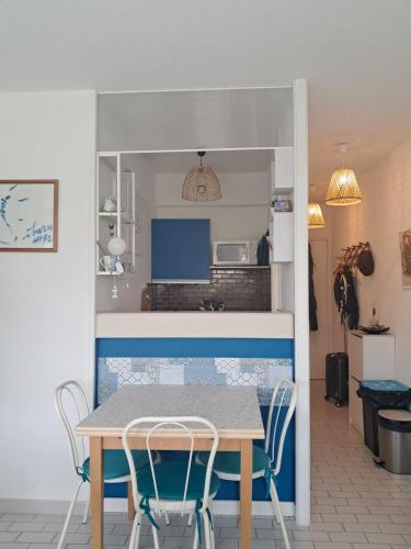 une cuisine et une salle à manger avec une table et des chaises dans l'établissement Appartement à 1 minute de la mer, à La Grande Motte