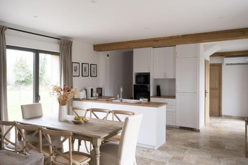 une cuisine et une salle à manger avec une table et des chaises dans l'établissement Maison du Haras Norman house near Deauville, à Cricquebœuf