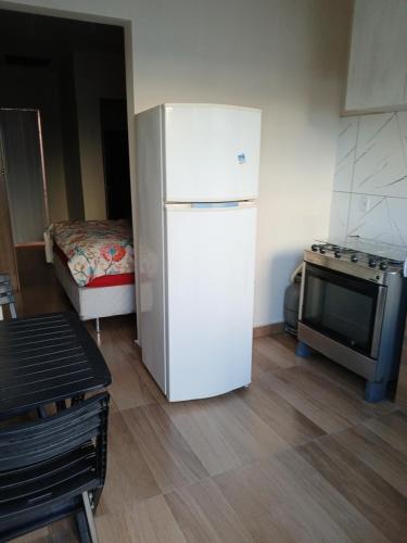 a kitchen with a refrigerator and a stove and a bed at Sinta se em casa in União da Vitória