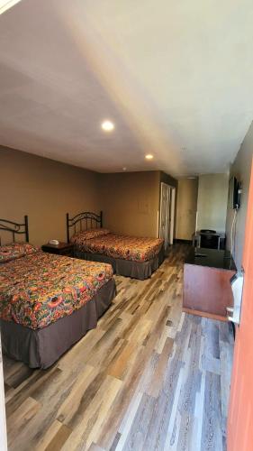 two beds in a hotel room with wooden floors at Live In Lodge Stone Mountain in Stone Mountain