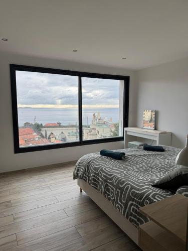 - une chambre avec un lit et de grandes fenêtres avec vue dans l'établissement L imprenable, à Marseille