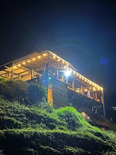 a building with lights on it on a hill at night at LP Finca la Pergola, Naturaleza con Lujo y una increíble vista a todo Medellín in Medellín