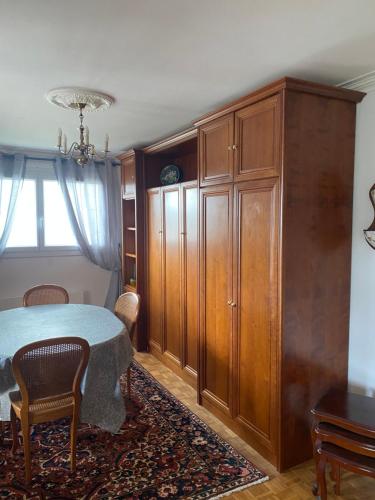 - une chambre avec une table et une grande armoire en bois dans l'établissement Appartement chaleureux, à Plestin-les-Grèves