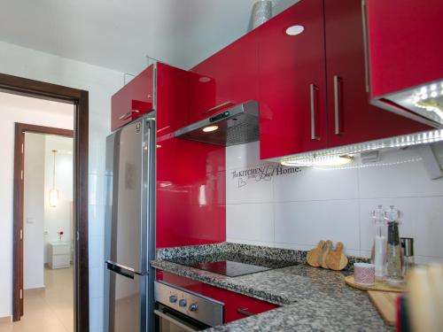 a kitchen with red cabinets and granite counter tops at Smart home in Cabo Negro