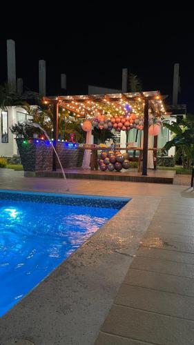 a building with lights and a swimming pool at night at Cabaña Villa Linda in Juan de Acosta