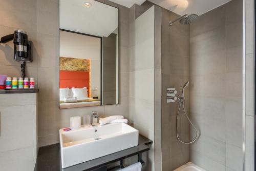 La salle de bains est pourvue d'un lavabo et d'une douche. dans l'établissement Hotel Scarlett, à Paris
