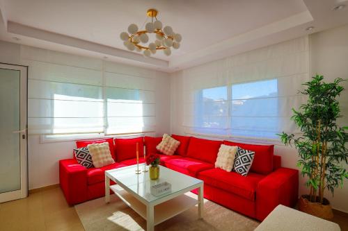 a living room with a red couch and a table at Smart home in Cabo Negro