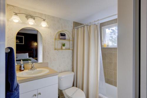 a bathroom with a toilet and a sink and a mirror at Vibrant Modern Escape, Walk To Dining, Near Beach in Sarasota