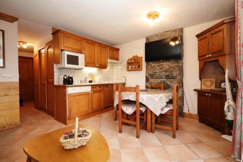 une cuisine avec des placards en bois, une table et une table dans l'établissement Résidence Les Hauts De Chavants - Hauts de chavants Albert 1er n°3 MAE-2651, aux Houches