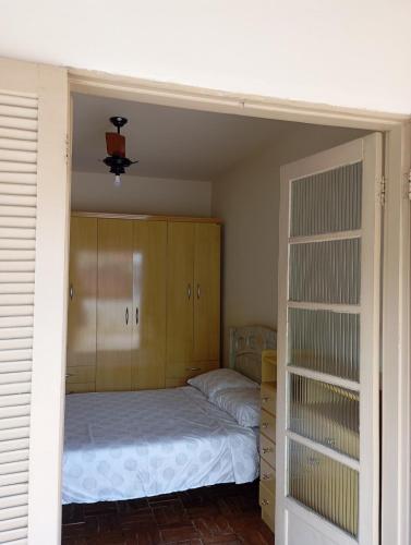 a bedroom with a bed and wooden cabinets at Casa em Aparecida SP in Aparecida