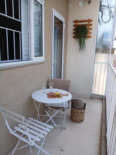 a white table and chairs on a balcony at Hospedagem Quarto Chic centro Cunha in Cunha