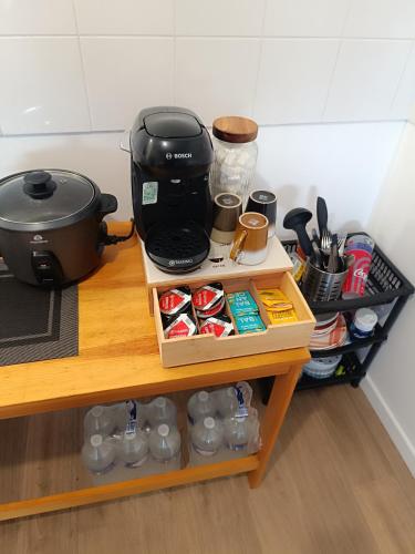 une cafetière assise sur une table à côté d'une étagère dans l'établissement Chic appartement F2, à Conflans-Sainte-Honorine