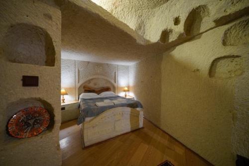 a bedroom with a bed in a stone wall at Asteria Cave Hotel in Goreme